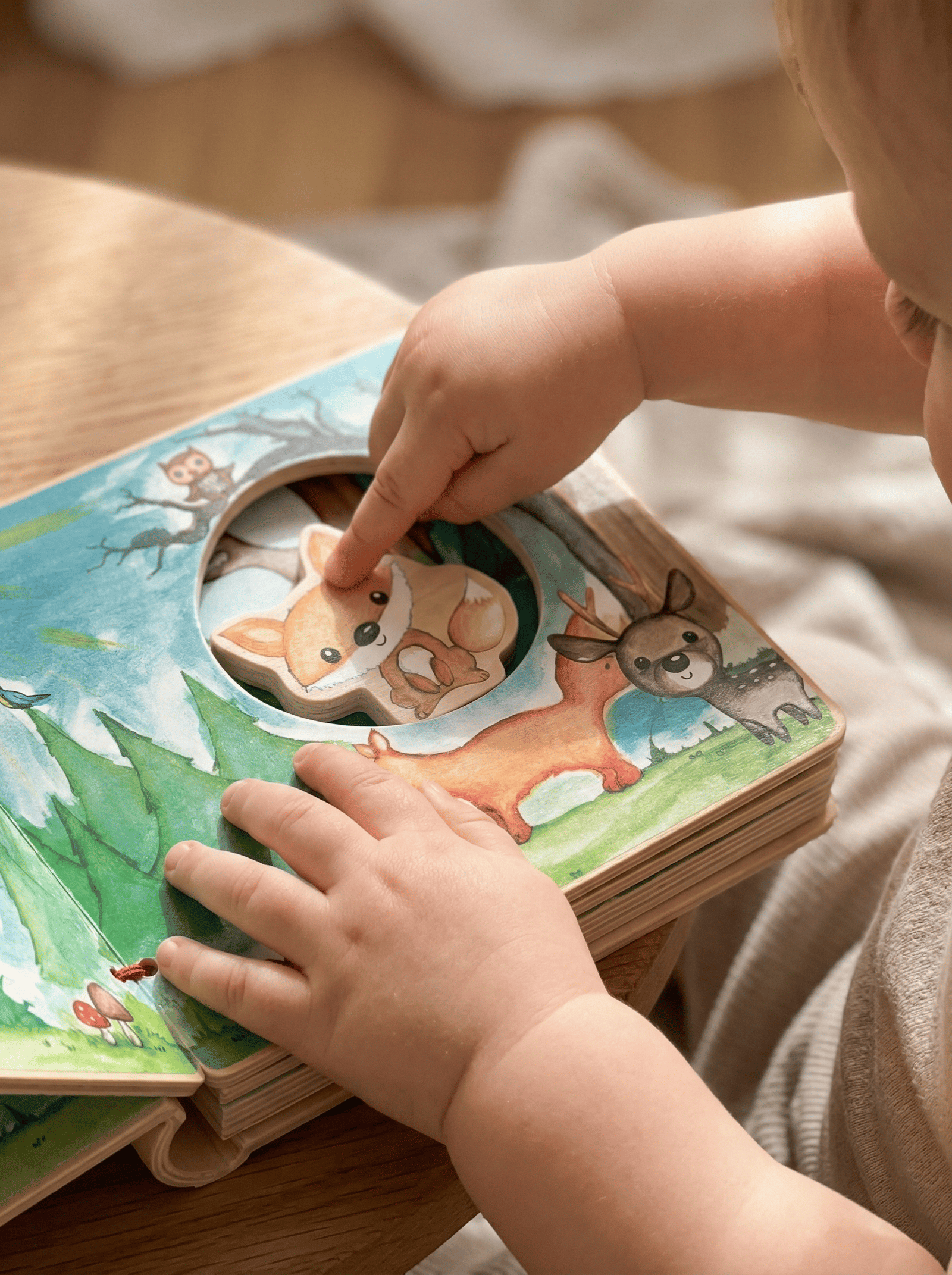 Livro interativo em madeira FSC® com animais da floresta. Estimula imaginação, motricidade fina e storytelling através de ilustrações e peças em madeira.